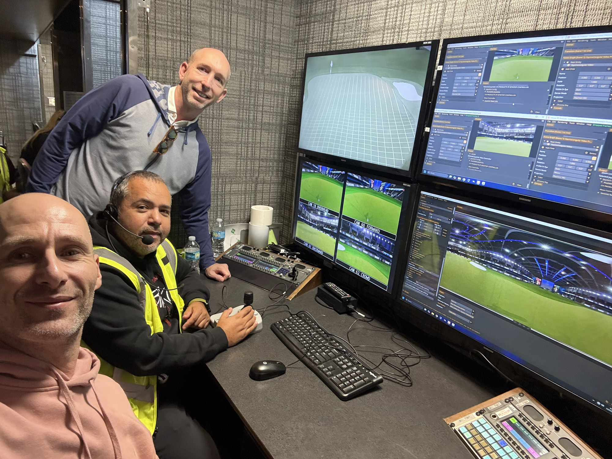 Crew members take a selfie in a broadcast control room in front of monitors showing the SmartPin feed.
