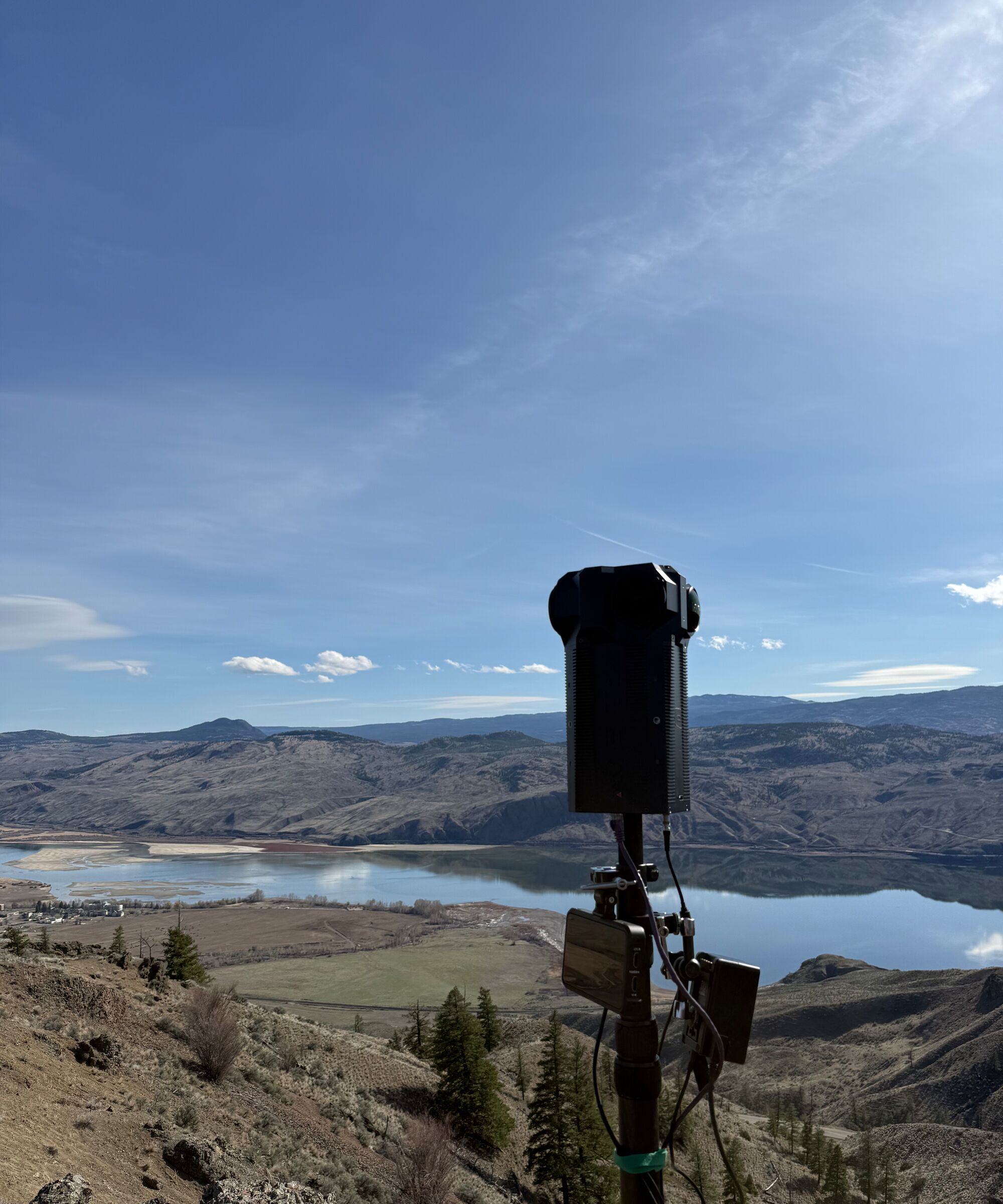 The Meta Four on a pole on a dry grassland ridge above a lake and valley.