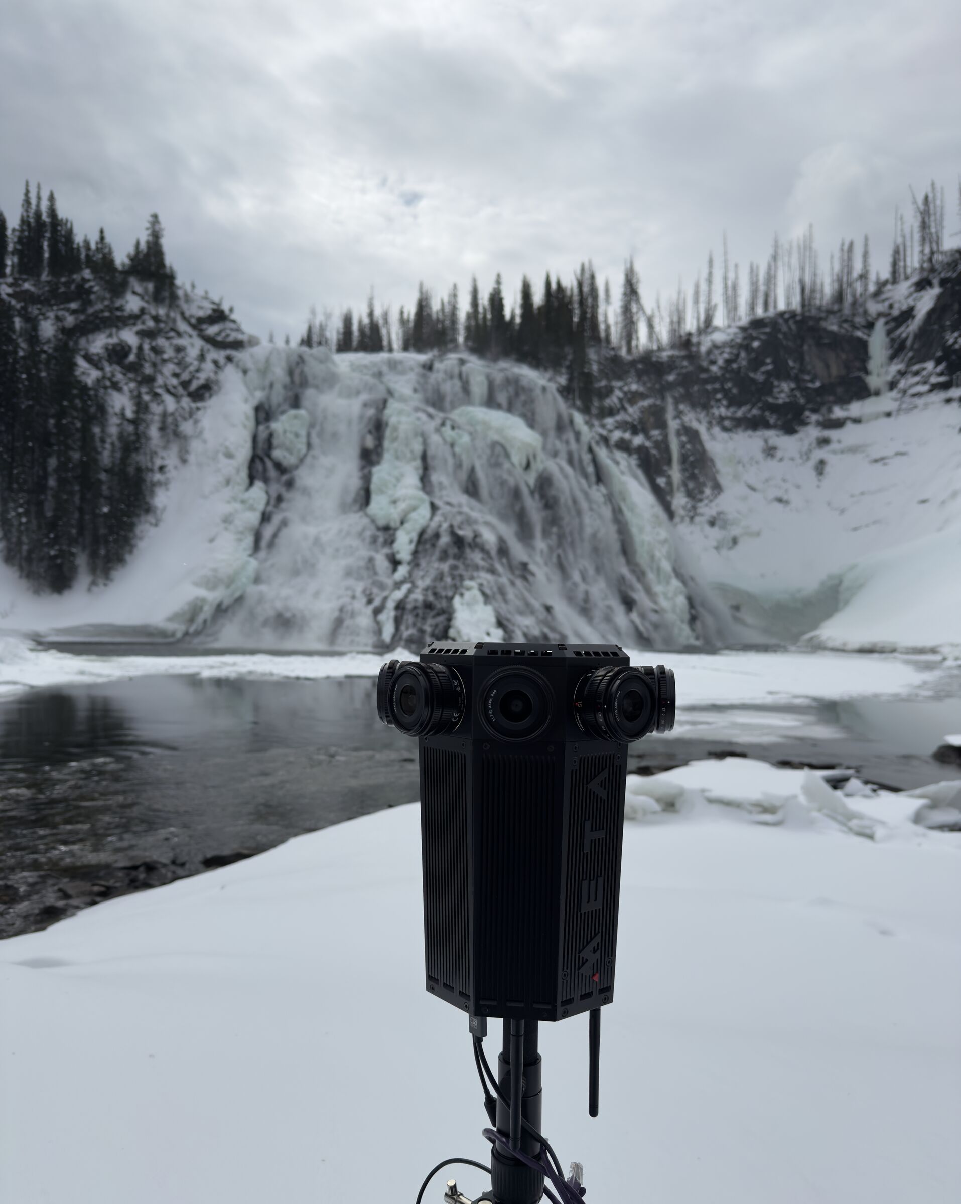 The Meta Four on a tripod in front of a frozen waterfall in a snowy bowl.